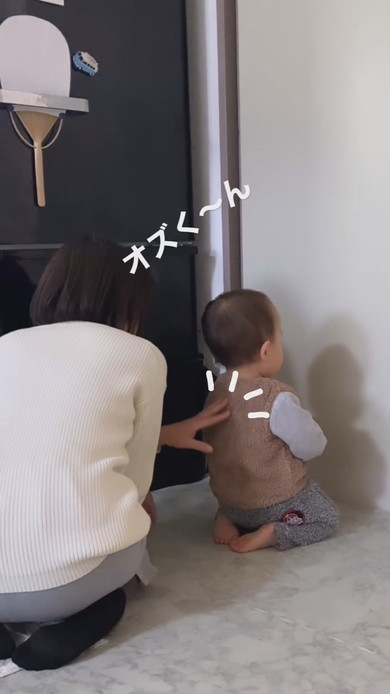 すねて正座し壁を向いている1歳児