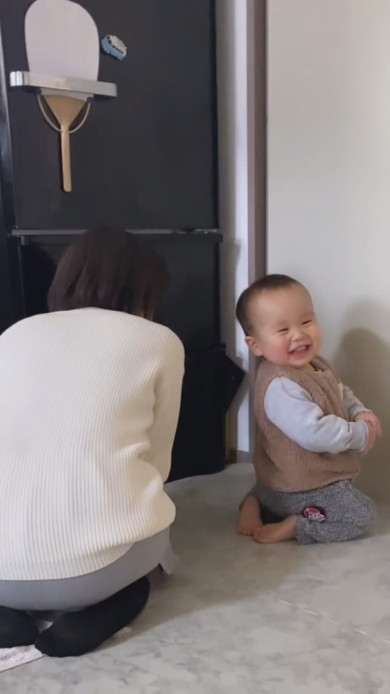 正座をしながら笑顔で振り向く1歳児