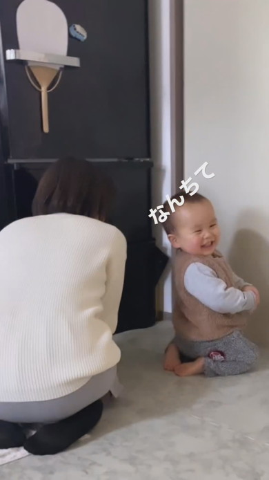 正座をしながら笑顔で振り向く1歳児