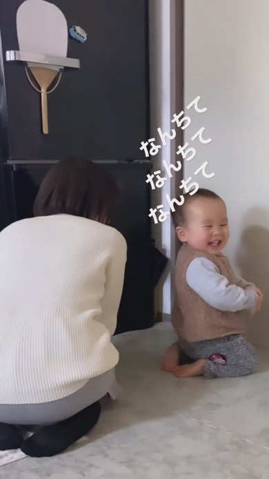 正座をしながら笑顔で振り向く1歳児