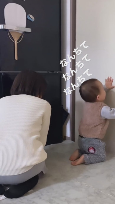 正座をしながら笑顔で振り向く1歳児
