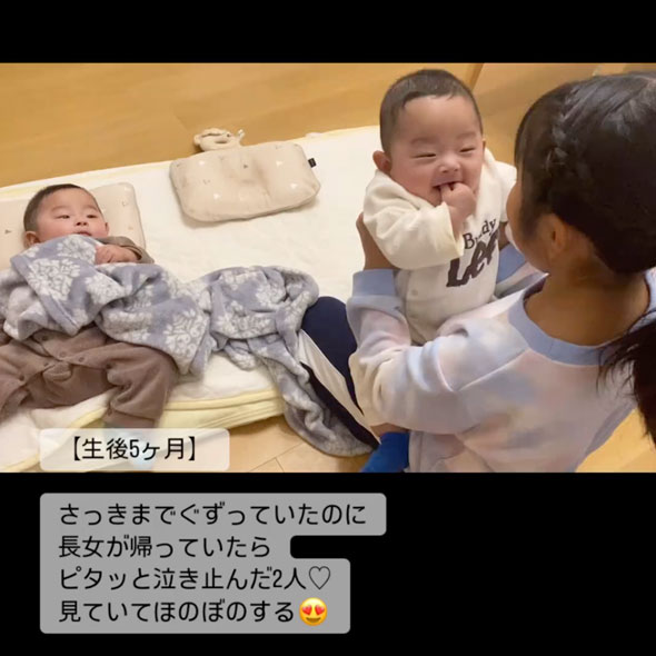 双子の赤ちゃんをあやす9歳の姉