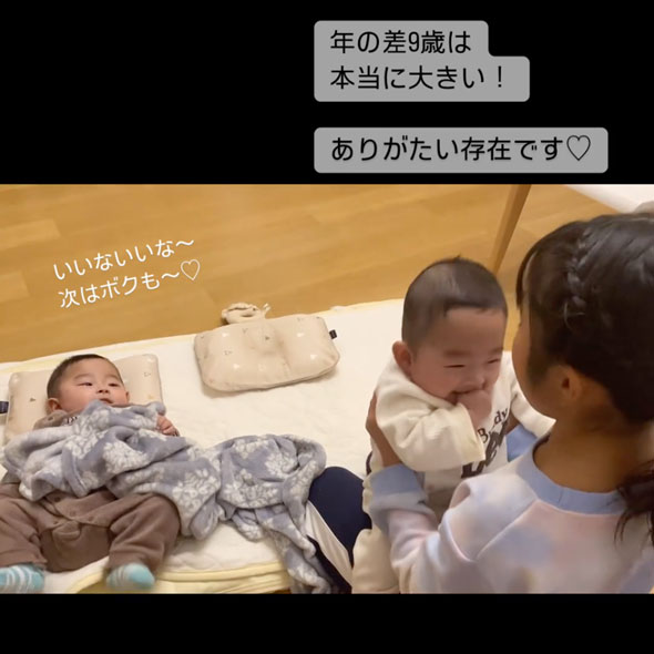 双子の赤ちゃんをあやす9歳の姉