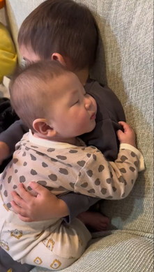 赤ちゃんを寝かしつける子ども