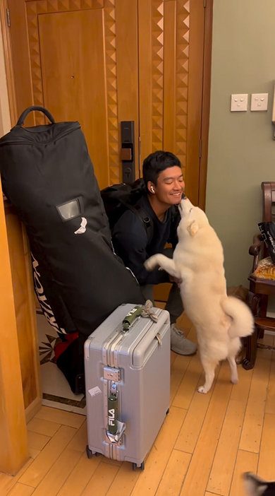 お兄ちゃんの口元をなめる白いワンコ