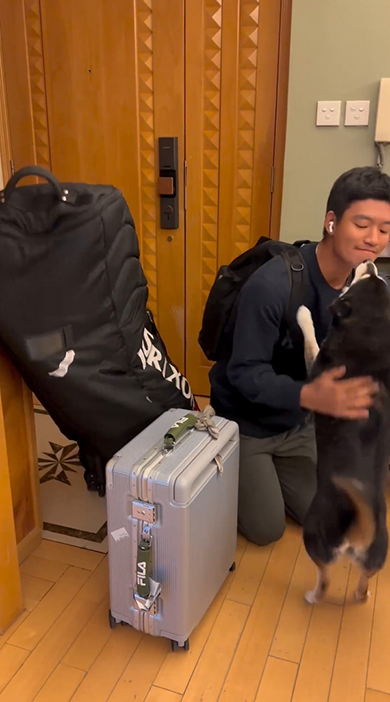 お兄ちゃんの口元をなめる黒いワンコ