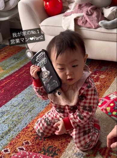 険しい表情で電話対応をする赤ちゃん