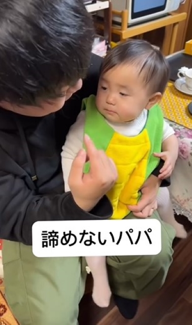赤ちゃんをひざに乗せたパパ