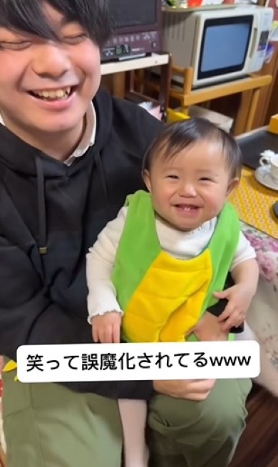 赤ちゃんをひざに乗せたパパ