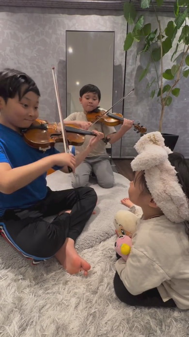 妹の前でバイオリンを演奏する兄2人