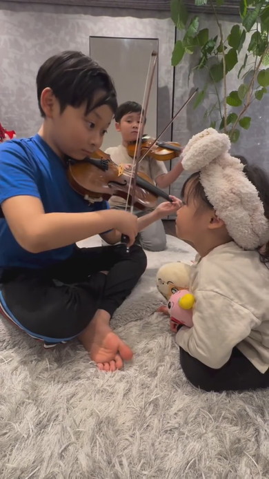 妹の前でバイオリンを演奏する兄2人