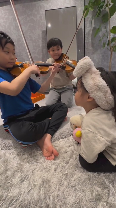 妹の前でバイオリンを演奏する兄2人
