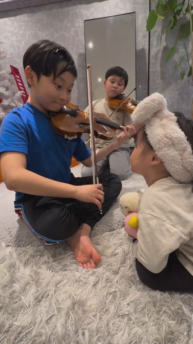 妹の前でバイオリンを演奏する兄2人