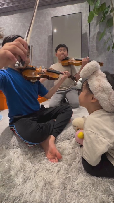 妹の前でバイオリンを演奏する兄2人