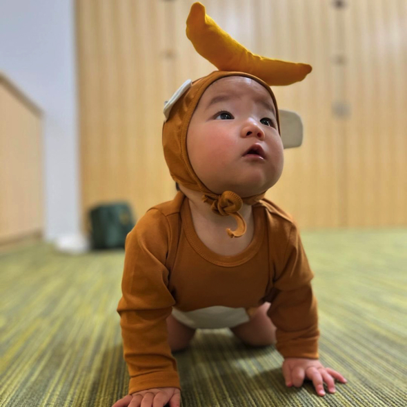 お猿さんの洋服を着る赤ちゃん