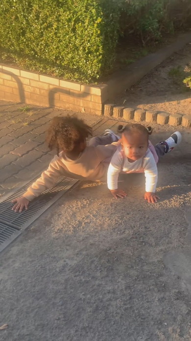 側溝で腹ばいになる兄を乗り越えていく妹