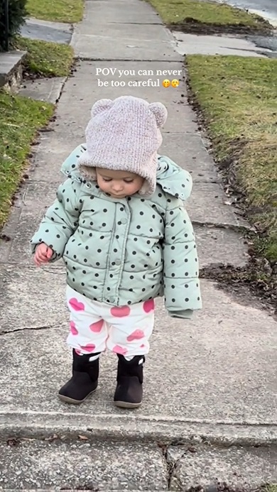 散歩中に出くわした小さな段差を注意深く下りる赤ちゃん