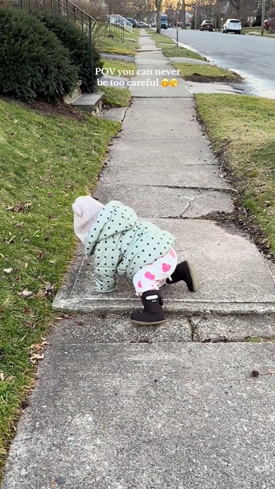 散歩中に出くわした小さな段差を注意深く下りる赤ちゃん