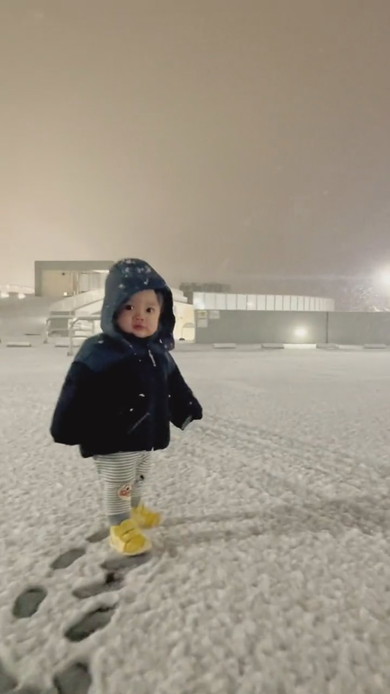 雪原の中を歩く1歳の男の子