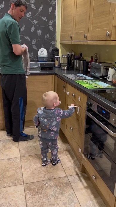 チャイルドロックを解除してパパのお手伝いをする2歳の子ども