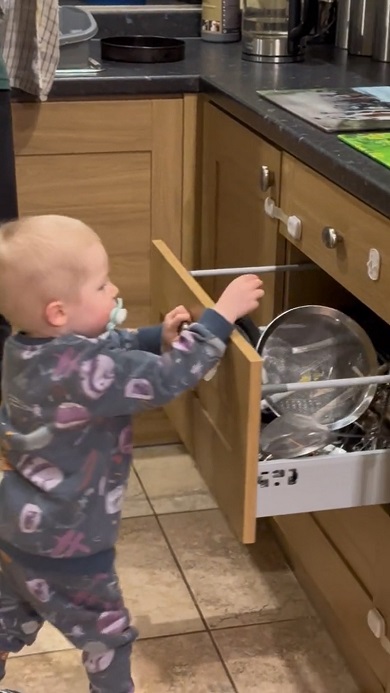 チャイルドロックを解除してパパのお手伝いをする2歳の子ども