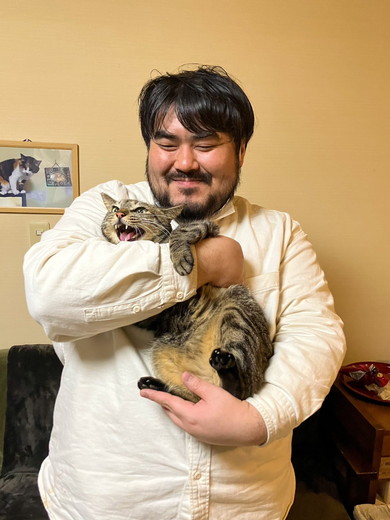 男性に抱っこされて嫌そうな顔をする猫ちゃん