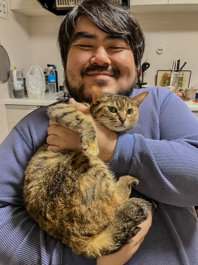 男性に抱っこされて嫌そうな顔をする猫ちゃん