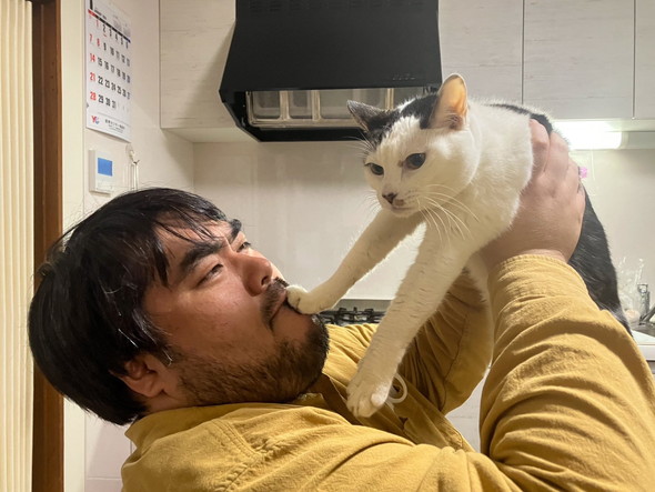 男性に抱っこされて嫌そうな顔をする猫ちゃん