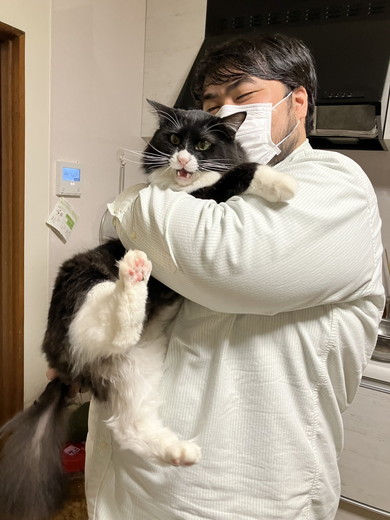 男性に抱っこされて嫌そうな顔をする猫ちゃん