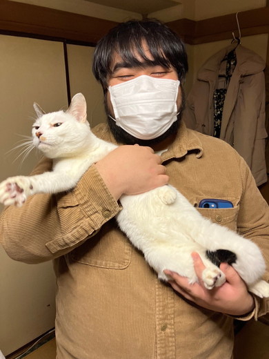 男性に抱っこされて嫌そうな顔をする猫ちゃん