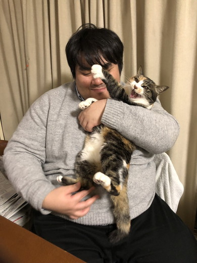 男性に抱っこされて嫌そうな顔をする猫ちゃん