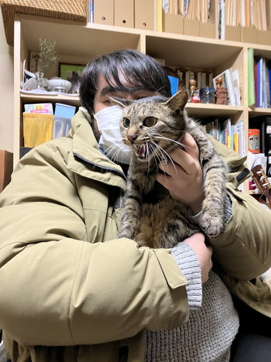 男性に抱っこされて嫌そうな顔をする猫ちゃん