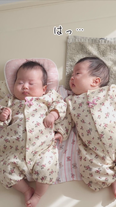 陽だまりの中で並んで寝る双子の赤ちゃん