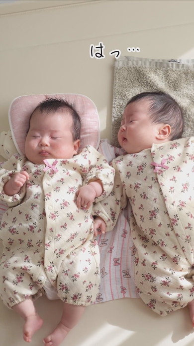 陽だまりの中で並んで寝る双子の赤ちゃん