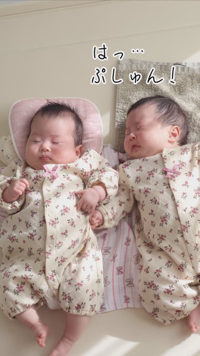 陽だまりの中で並んで寝る双子の赤ちゃん
