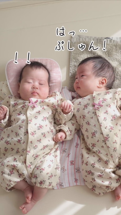 陽だまりの中で並んで寝る双子の赤ちゃん