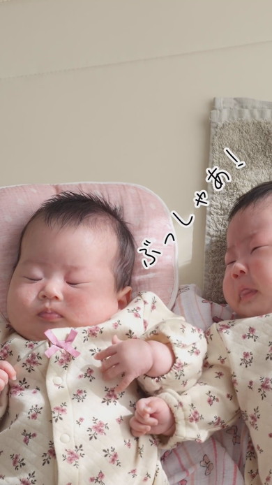 陽だまりの中で並んで寝る双子の赤ちゃん
