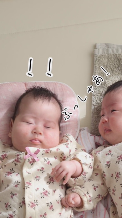 陽だまりの中で並んで寝る双子の赤ちゃん