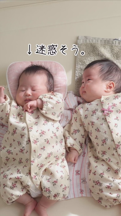 陽だまりの中で並んで寝る双子の赤ちゃん