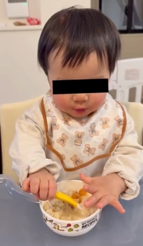 ごはんをすくう赤ちゃん