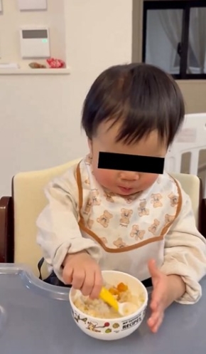 ごはんをすくう赤ちゃん