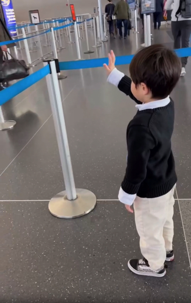 おばあちゃんを手を振って見送る孫