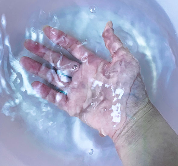 洗面器の水をすくう写真