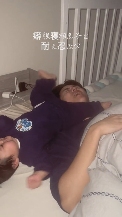 激しい寝相の息子と耐える父が並んで寝ている光景