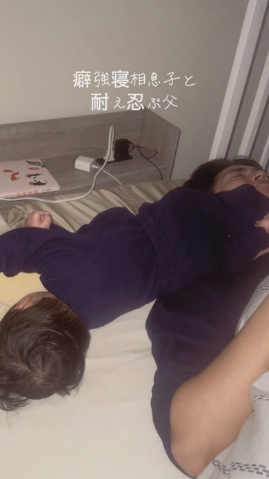 激しい寝相の息子と耐える父が並んで寝ている光景