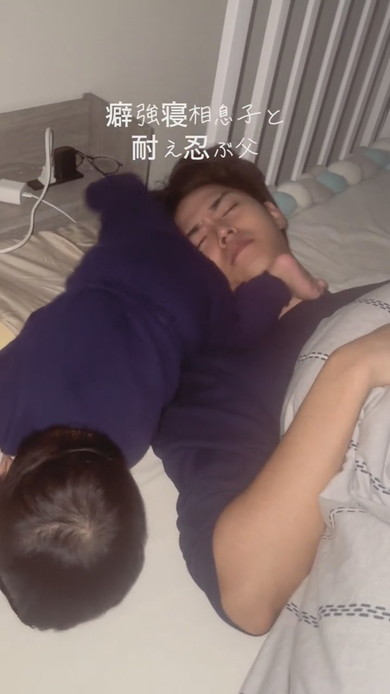 激しい寝相の息子と耐える父が並んで寝ている光景