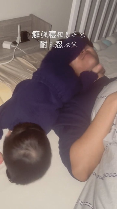 激しい寝相の息子と耐える父が並んで寝ている光景