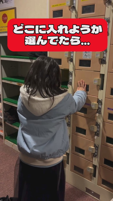 シューズロッカーの前で靴をどこに入れようか悩んでいる女の子