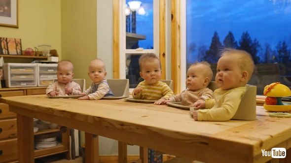 五つ子のために赤ちゃん用のいすが付いたテーブルを自作するパパ