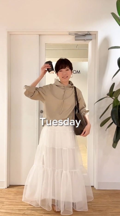 パーカーとティアードスカートを着た女性